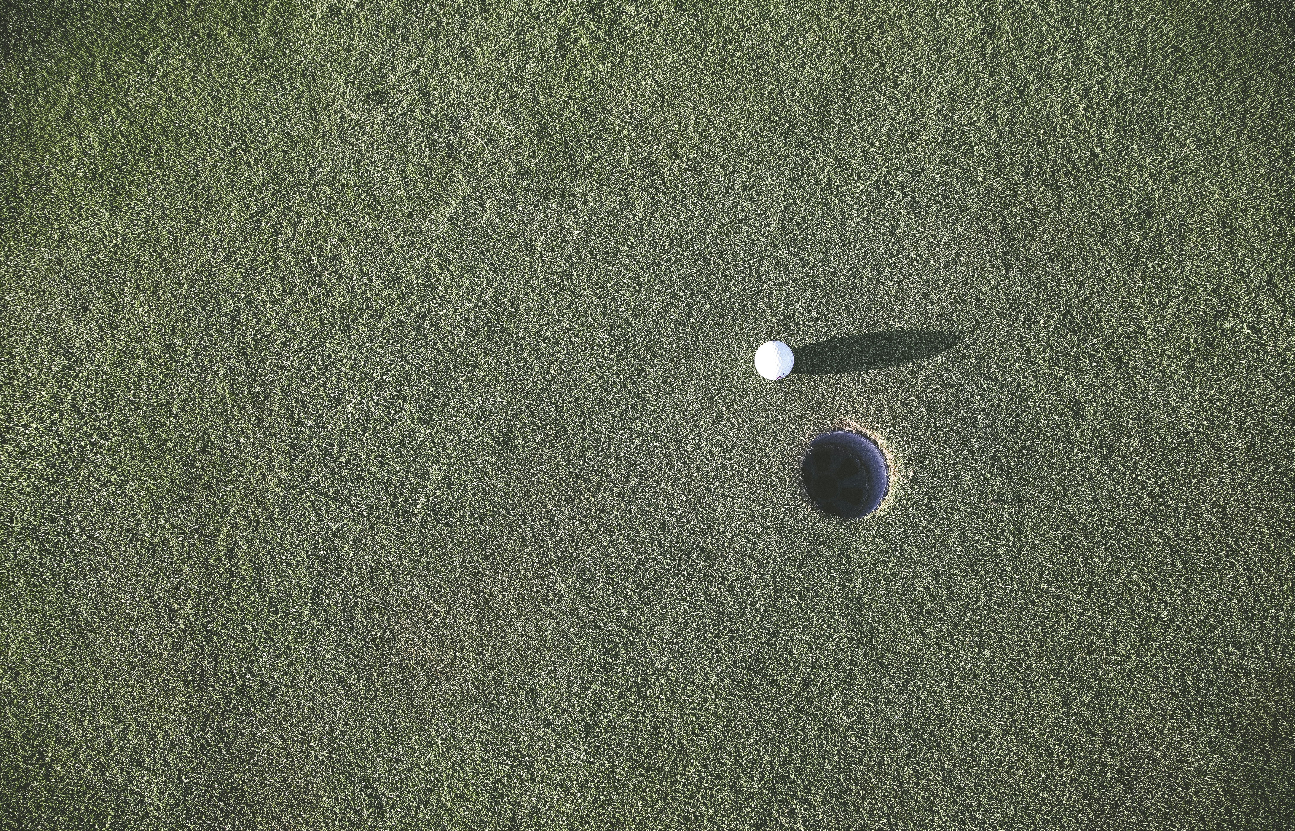 white golf ball near hole