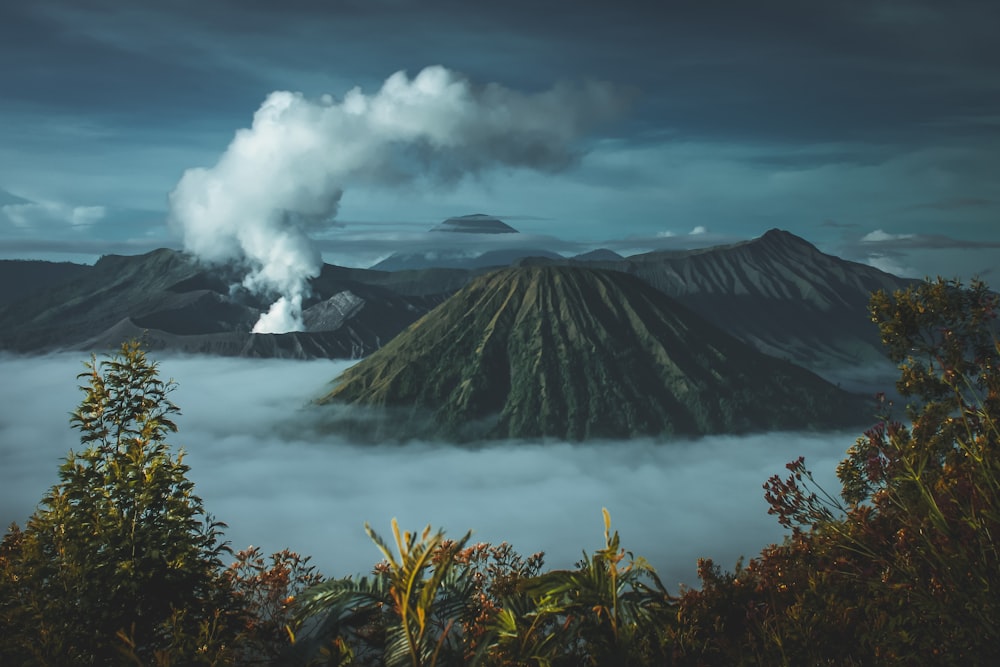 Des montagnes vertes entourées de nuages blancs