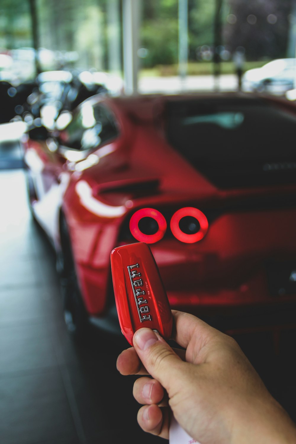 red person with keyfob of red Ferrari supercar