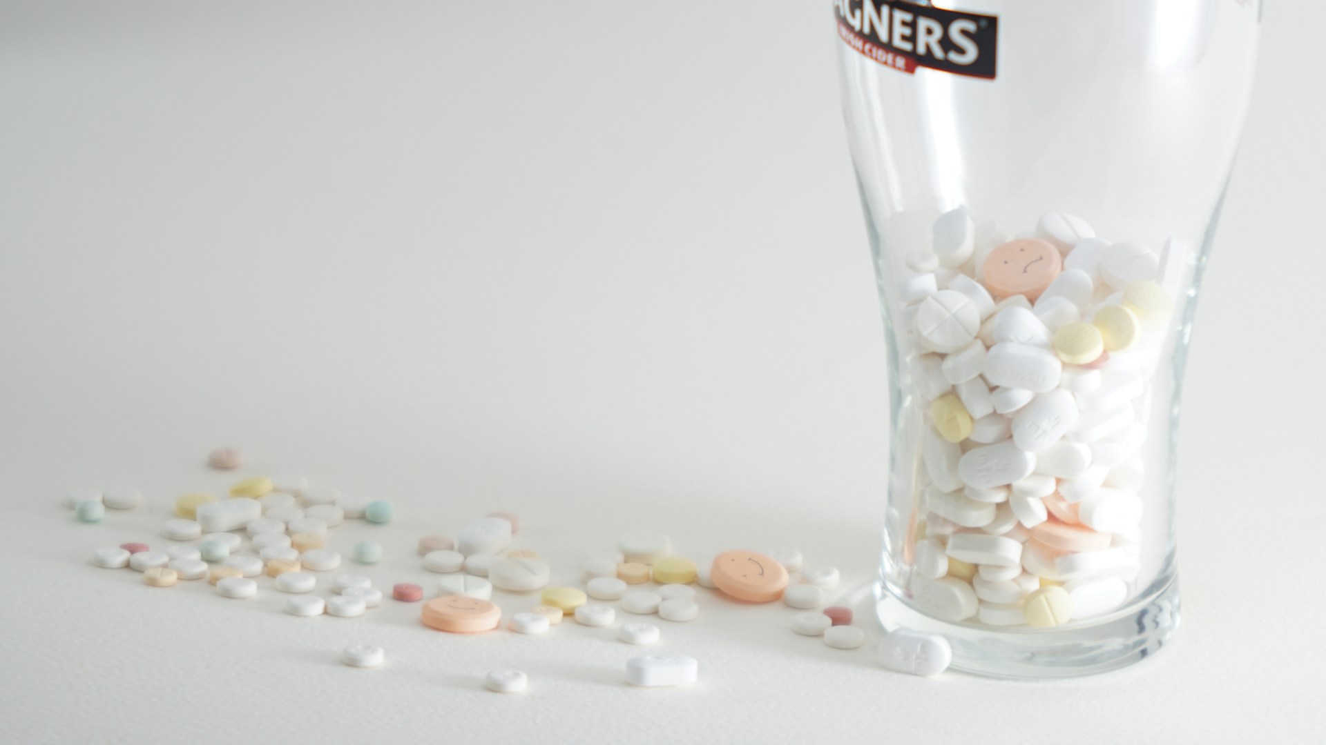 assorted medication pills in clear highball glass