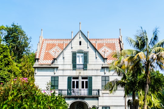 white building between trees in Monte Palace Tropical Garden Portugal