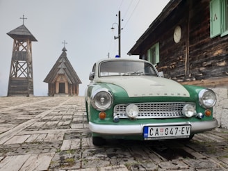 green and white vehicle near wooden buildings