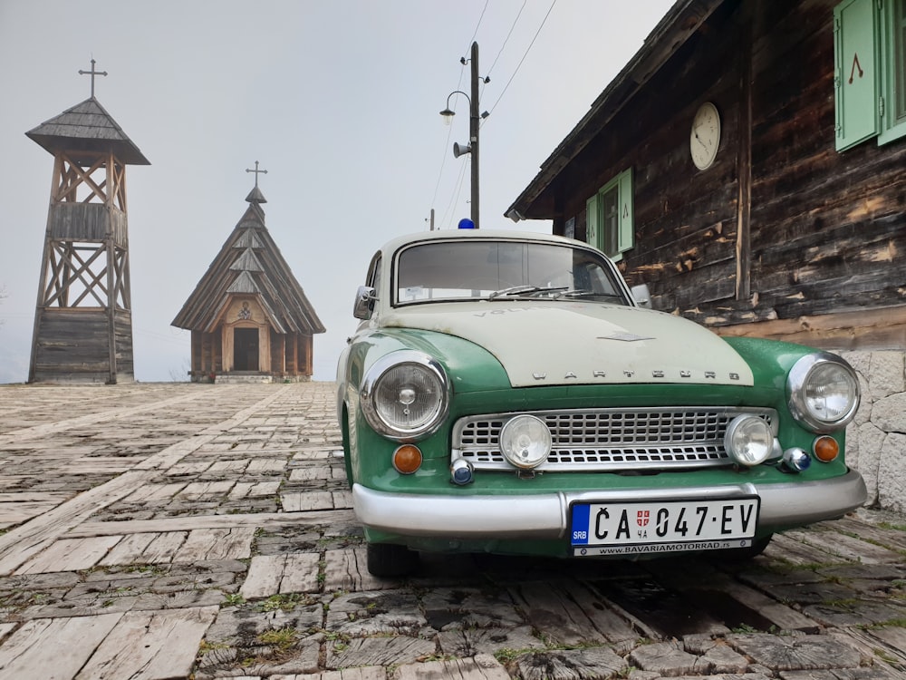 green and white vehicle near wooden buildings