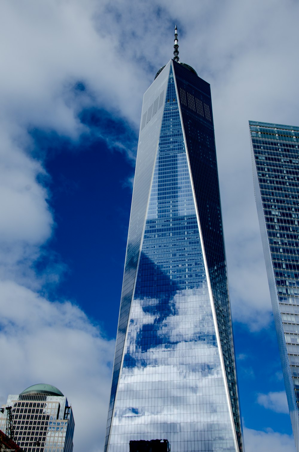nubes blancas sobre un edificio alto con fachada de vidrio