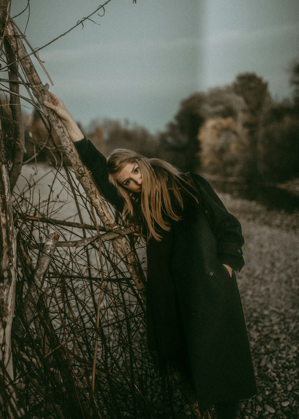 woman standing beside twigs