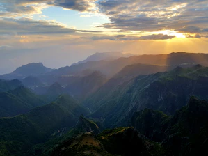 Sunset view over lush green valleys and jagged mountain ridges of the Prokletije range.