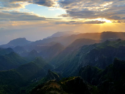 Sunset view over lush green valleys and jagged mountain ridges of the Prokletije range.