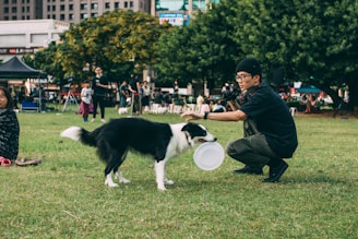 man holding black and white dog