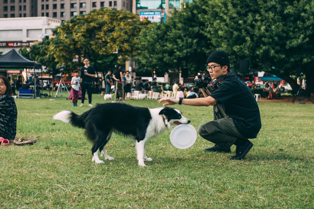 man holding black and white dog