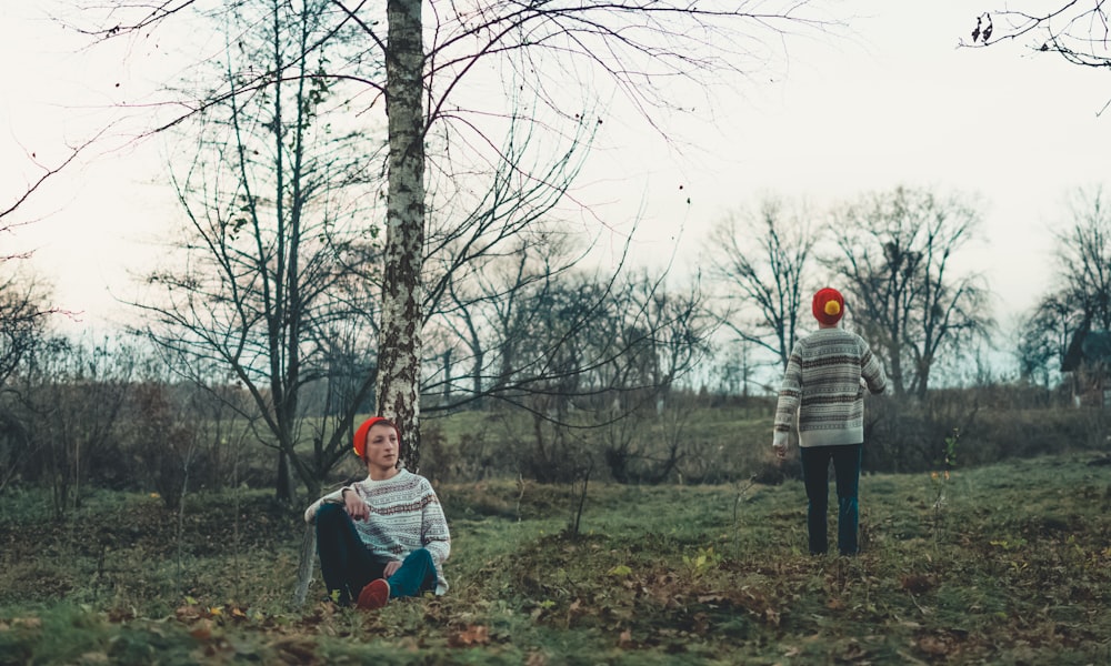 man sitting beside tree