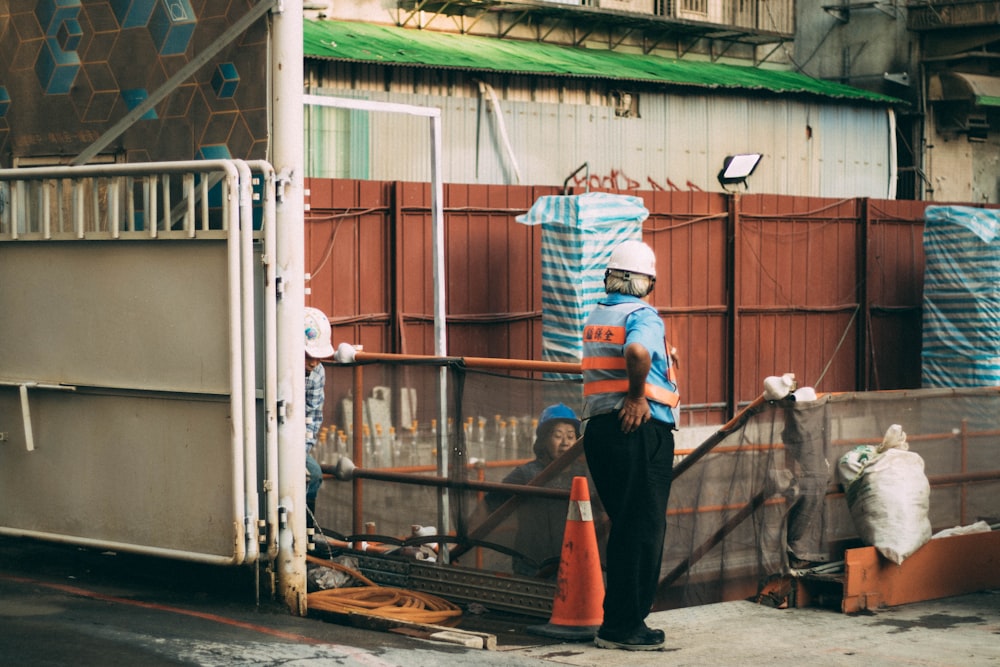 man standing beside traffic cone