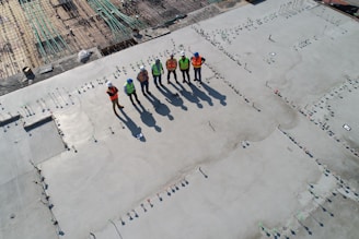 seven construction workers standing on white field