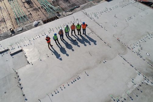 Construction workers collaborating on a concrete slab project at a sunny site