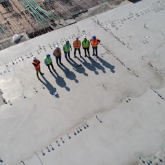 seven construction workers standing on white field