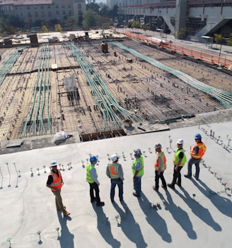 seven construction workers standing on white field