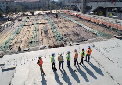 seven construction workers standing on white field