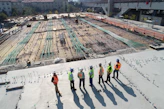 seven construction workers standing on white field