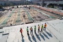 seven construction workers standing on white field