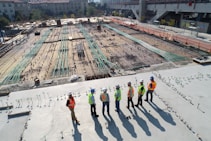 seven construction workers standing on white field