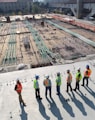 seven construction workers standing on white field