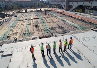 seven construction workers standing on white field