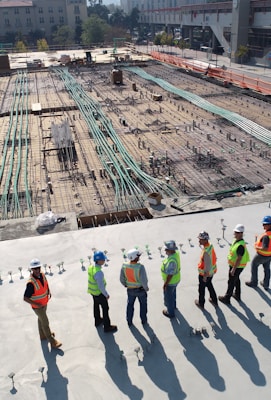 seven construction workers standing on white field