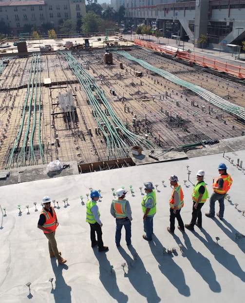seven construction workers standing on white field