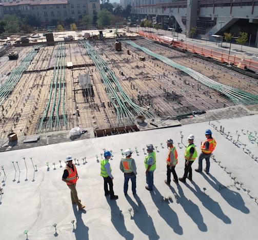 seven construction workers standing on white field