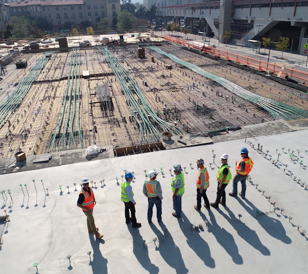 seven construction workers standing on white field