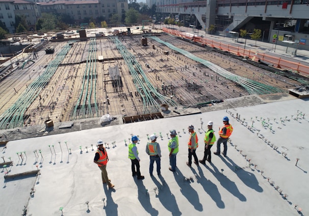 seven construction workers standing on white field