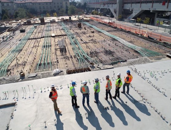 seven construction workers standing on white field