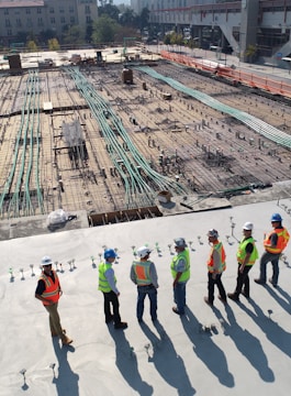 seven construction workers standing on white field