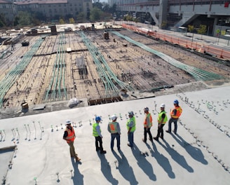 seven construction workers standing on white field