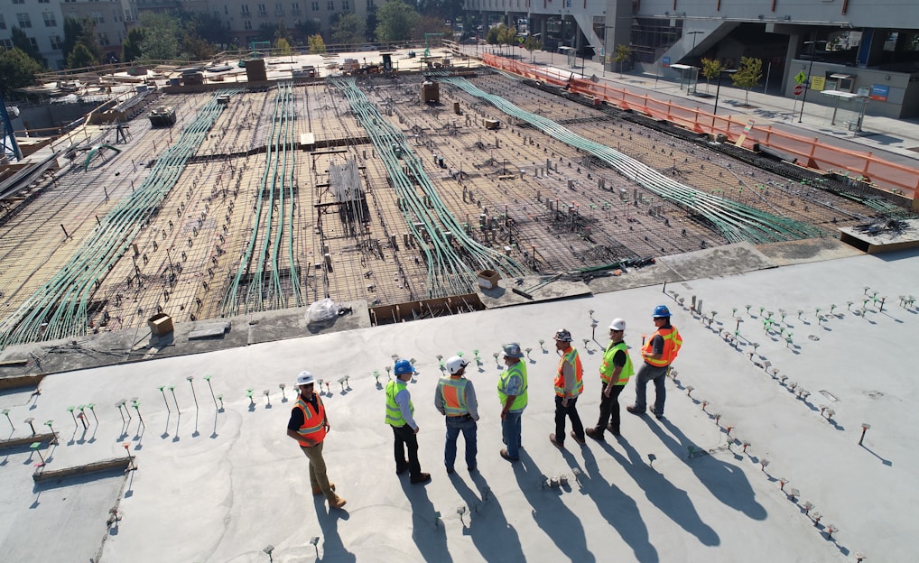 seven construction workers standing on white field