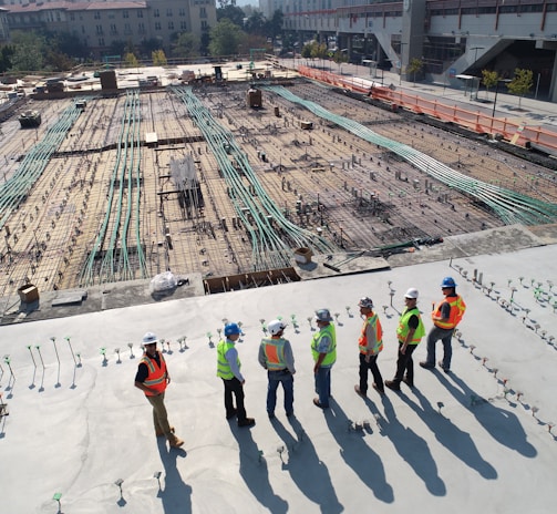 seven construction workers standing on white field