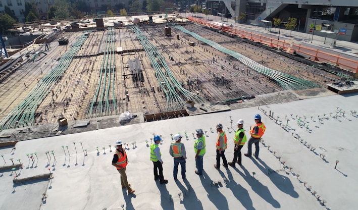 seven construction workers standing on white field