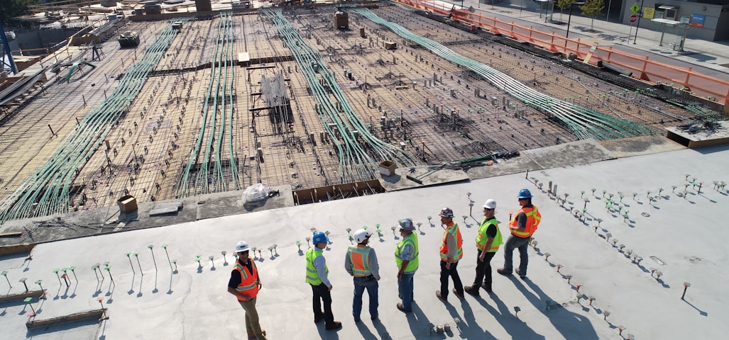 seven construction workers standing on white field