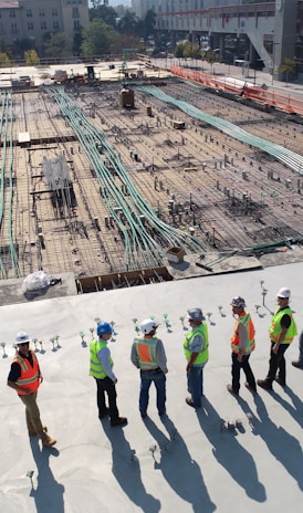 seven construction workers standing on white field