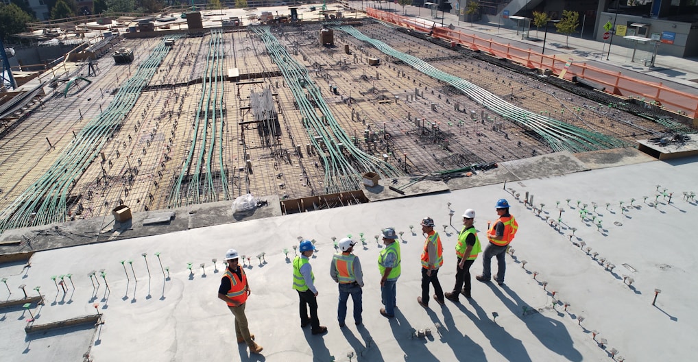 seven construction workers standing on white field