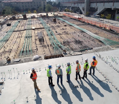 seven construction workers standing on white field