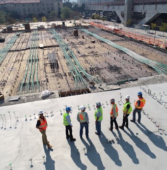 seven construction workers standing on white field