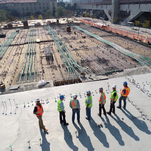 seven construction workers standing on white field