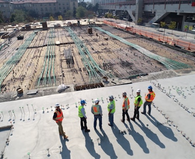 seven construction workers standing on white field