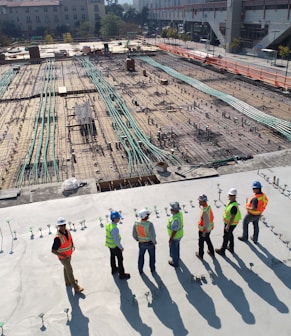 seven construction workers standing on white field