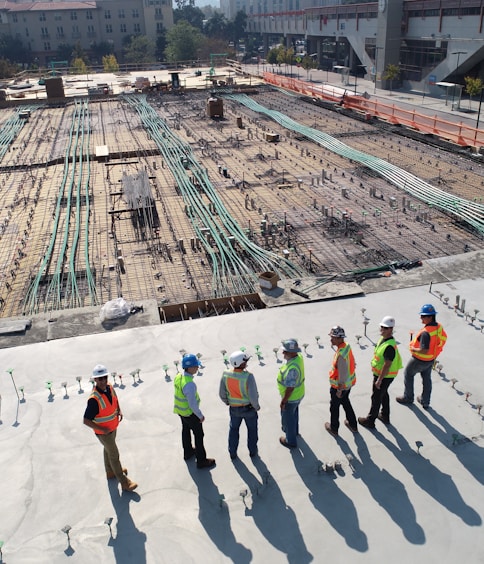 seven construction workers standing on white field