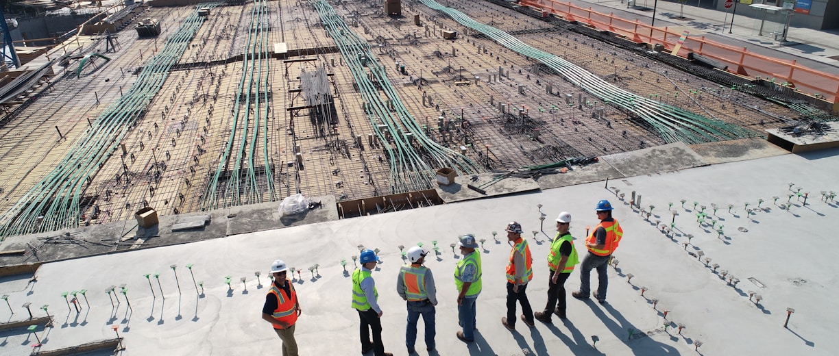 seven construction workers standing on white field