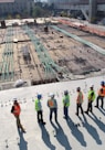 seven construction workers standing on white field