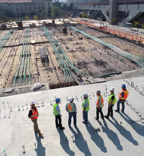 seven construction workers standing on white field