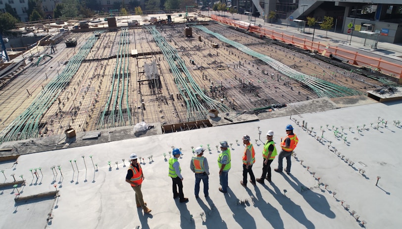 seven construction workers standing on white field