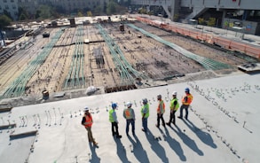 seven construction workers standing on white field